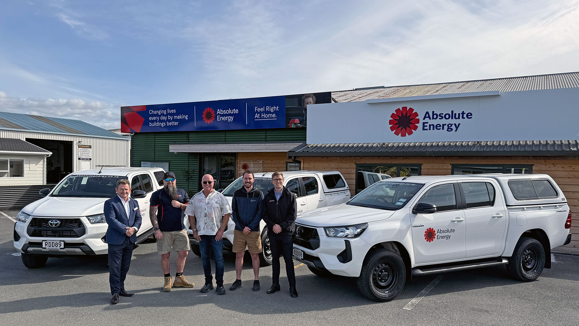 A group of people standing in front of a fleet of Toyota Hilux